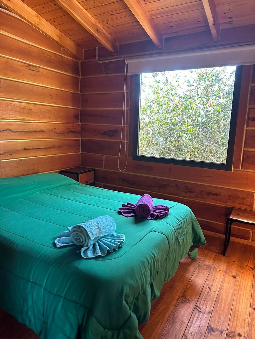 Dormitorio de una cabaña, con las toallas preparadas sobre la cama