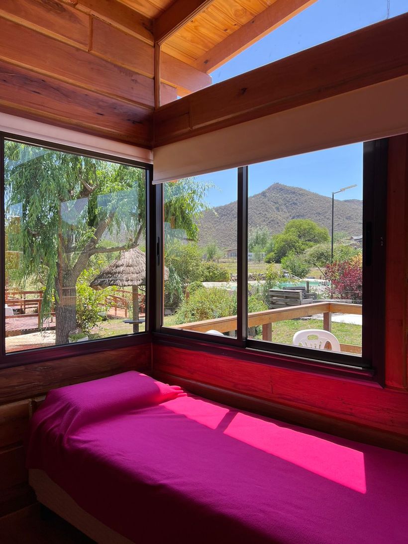 Dormitorio con un ventanal que da a las sierras