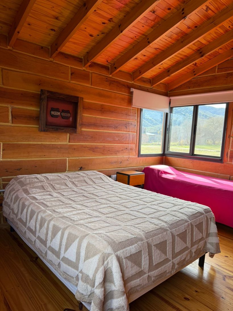 Habitación con cama matrimonial y ventana al verde
