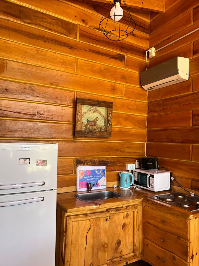 Cocina de la cabaña con heladera, microondas y anafe