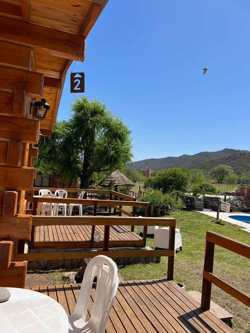 Galería de madera de una de las cabañas, con vista al parque
