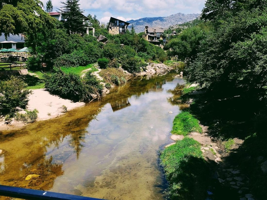 El arroyo de La Cumbrecita entre casas de montaña y vegetación
