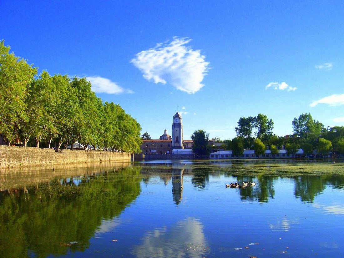 El Tajamar de Alta Gracia con la iglesia y la torre del reloj reflejadas en el agua